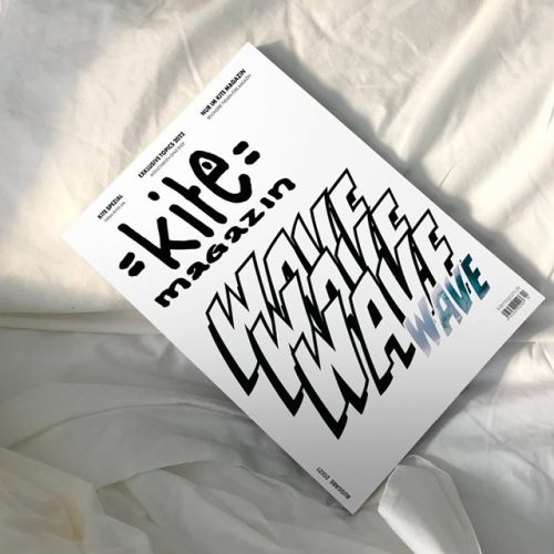 Picture is showing a cover desing of a kite magazine which is placed in a bed between the sheets